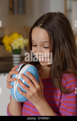 Ragazza cerca curiosamente in un grande uovo di pasqua, regalo di Pasqua, Alta Baviera, Baviera, Germania Foto Stock