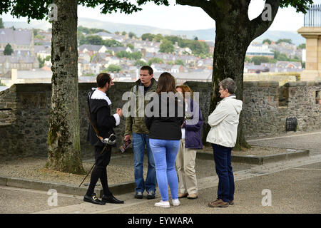 Attore in costume di parlare con i turisti in Derry pareti durante la fanciulla Festival della città Foto Stock