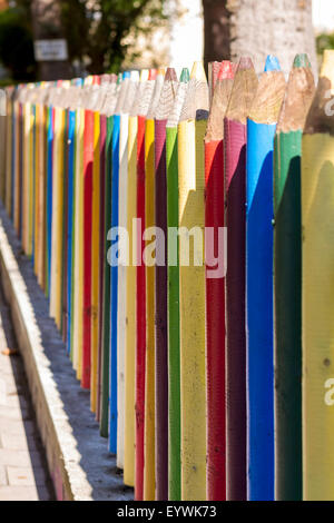 Recinzione di matite colorate al di fuori di una scuola materna. Bella la profondità di campo. Foto Stock