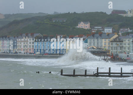 Aberystwyth, Wales, Regno Unito. Il 4 agosto 2015. Le tempeste. Un 5-8 piedi si gonfiano, venti alti e un alta marea cmbine per ancorare Aberystwyth mare con onde enormi, come operai a proseguire i lavori sul lungomare di rivalorizzare bandstand Credito: Alan Hale/Alamy Live News Foto Stock