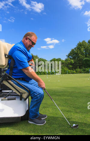 Uomo con una lesione del midollo spinale in un carrello adattabile a golf putting green Foto Stock