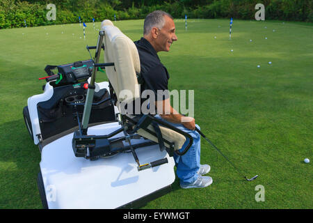 Uomo con una lesione del midollo spinale in un carrello adattabile a golf putting green Foto Stock