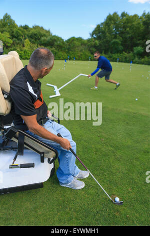 Uomo con una lesione del midollo spinale in un carrello adattabile a golf putting green Foto Stock