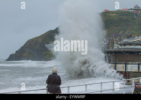 Aberystwyth, Wales, Regno Unito. Il 4 agosto 2015. Le tempeste. Un 5-8 piedi si gonfiano, venti alti e un alta marea cmbine per ancorare Aberystwyth mare con onde enormi, come operai a proseguire i lavori sul lungomare di rivalorizzare bandstand Credito: Alan Hale/Alamy Live News Foto Stock