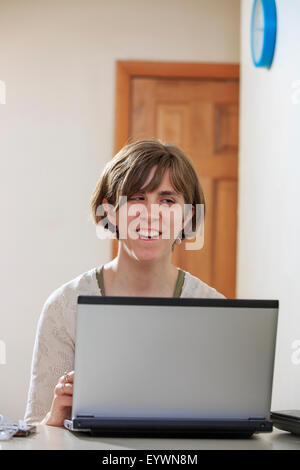 Donna cieca utilizzando la tecnologia assistiva al suo computer per ascoltare Foto Stock
