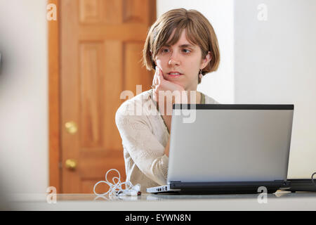 Donna cieca utilizzando la tecnologia assistiva al suo computer per ascoltare Foto Stock
