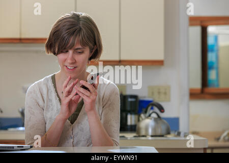 Donna cieca utilizzando la tecnologia assistiva per ascoltare il suo telefono cellulare Foto Stock
