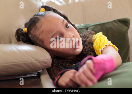 Bambina con paralisi cerebrale seduti a casa Foto Stock