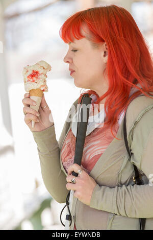 Giovane donna cieca con la sua canna da zucchero godendo di gelato Foto Stock