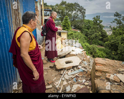 Luglio 31, 2015 - Kathmandu, Nepal - I monaci buddisti guardare il relitto di un monastero buddista a Swayambhunath, noto anche come il Tempio delle Scimmie. Due monaci sono stati uccisi quando il monastero fu distrutto dal terremoto. Swayambhunath è un complesso di templi buddisti e indù a Kathmandu. Fu gravemente danneggiata nel terremoto del Nepal. Il Nepal terremoto del 25 aprile 2015, (noto anche come il terremoto di Gorkha) ha ucciso più di 9 mila persone e il ferimento di più di 23.000. Essa aveva una grandezza di 7,8. © ZUMA Press, Inc. Foto Stock