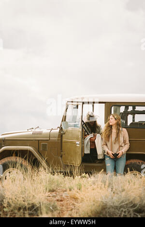 Due donne da un 4x4 in un deserto, prendendo una pausa dalla strada. Foto Stock
