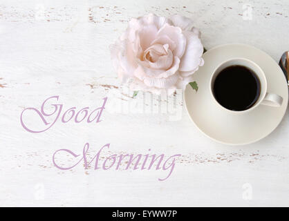 Una tazza di caffè nero e un fiore - buona mattina testo Foto Stock