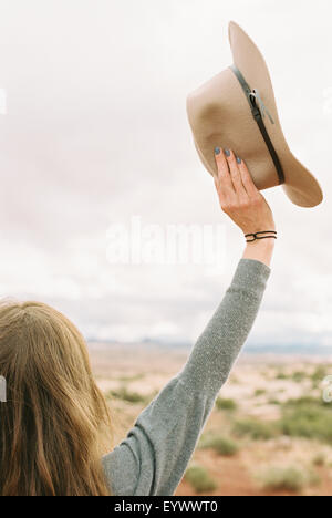 Donna in piedi con le braccia sollevate in aria. Foto Stock