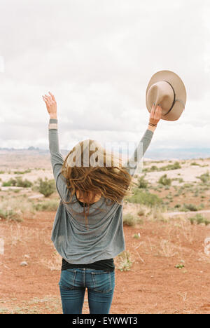 Donna in piedi con le braccia sollevate in aria. Foto Stock