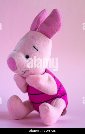 Maialino morbido peluche da Winnie the Pooh isolato su sfondo rosa Foto Stock