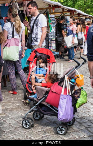 Berlin Mauer Park Mercato delle Pulci - che la gente guarda le bancarelle del mercato e i bambini stanchi di attendere in carrozzina Foto Stock