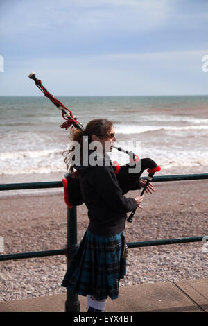 Sidmouth, Devon, Regno Unito. Il 4° agosto 2015. Un musicista di strada giovane riprodurre musiche tradizionali scozzesi su cornamuse lungo l'Esplanade durante Sidmouth Folk Week. Il festival della musica folk di Sidmouth è stato tenuto dal 1955, ed è uno dei principali eventi nel la musica e la danza tradizionali calendario. Foto: Tony Charnock/Alamy Live News Foto Stock