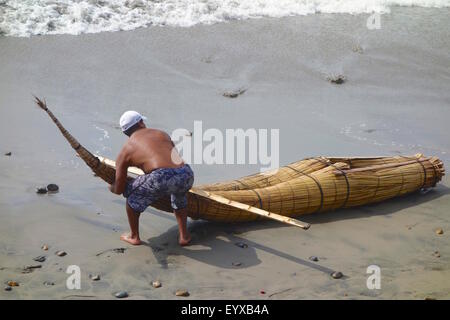 "Caballitos de totora', tradizionali barche da pesca fatta di canne, sulla spiaggia di Huanchaco, Perù. Foto Stock