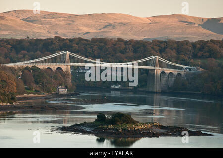 Il Menai Bridge crossing da Anglesey alla terraferma, con la calda luce del sole serale sulla Carneddau lontane montagne . Foto Stock