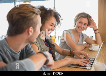 Amici sorridente con notebook e caffè appendere fuori cafe Foto Stock