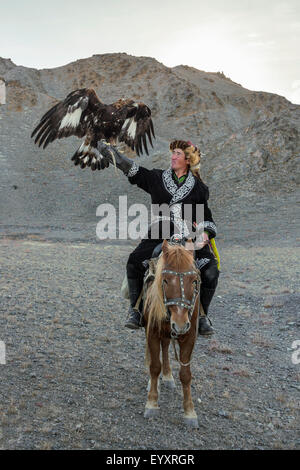 Il kazako eagle cacciatore con il suo ONU-incappucciati golden eagle tenuto alta #5, nelle steppe della Mongolia occidentale, a ovest di Olgii Foto Stock