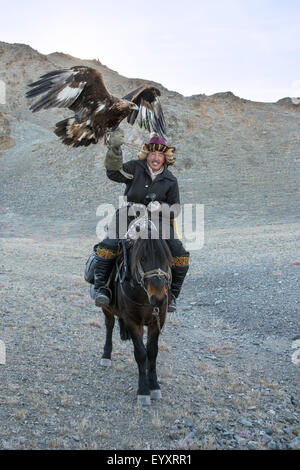 Il kazako eagle cacciatore con il suo ONU-incappucciati golden eagle tenuto alta #3, nelle steppe della Mongolia occidentale, a ovest di Olgii Foto Stock