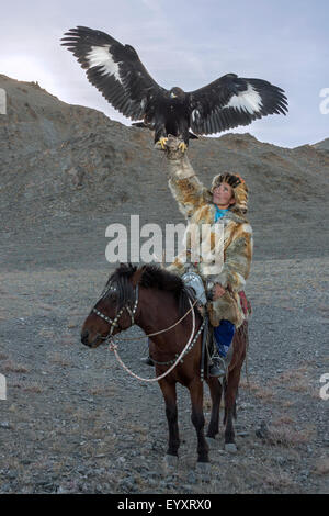 Il kazako eagle cacciatore con il suo ONU-incappucciati golden eagle tenuto alta #4, nelle steppe della Mongolia occidentale, a ovest di Olgii Foto Stock