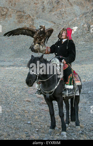 Il kazako eagle cacciatore con il suo ONU-incappucciati golden eagle tenuto alta #2, nelle steppe della Mongolia occidentale, a ovest di Olgii Foto Stock