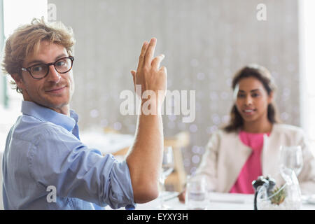 L'uomo gesticolando per il servizio al ristorante tabella Foto Stock