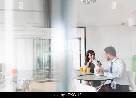 Imprenditore e imprenditrice cinese di mangiare cibo asporto in office caff Foto Stock