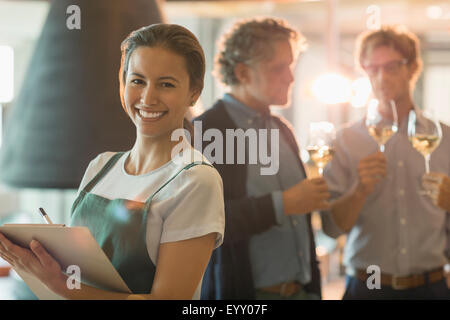 Ritratto di donna sorridente con appunti lavorando in sala degustazione vini Foto Stock