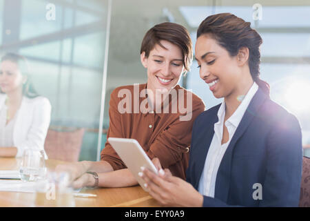 Sorridente imprenditrici utilizzando digitale compressa in office Foto Stock