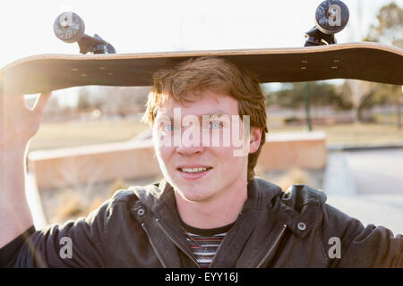 Caucasian ragazzo adolescente skateboard di bilanciamento sulla testa Foto Stock