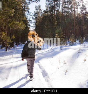 Mari uomo che porta le racchette da neve sul sentiero innevato Foto Stock