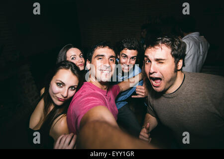 Sorridente amici prendendo selfie in discoteca Foto Stock