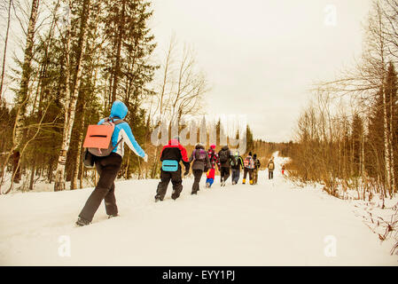 Caucasian gli escursionisti a piedi in una fila sul sentiero innevato Foto Stock