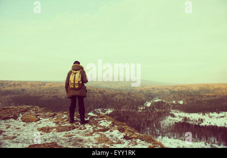 Escursionista caucasica ammirando vista panoramica dalla cima innevata Foto Stock