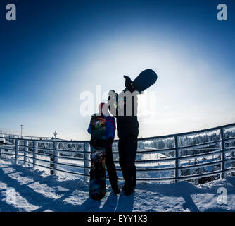 Gli appassionati di snowboard caucasica permanente sulla cima innevata Foto Stock