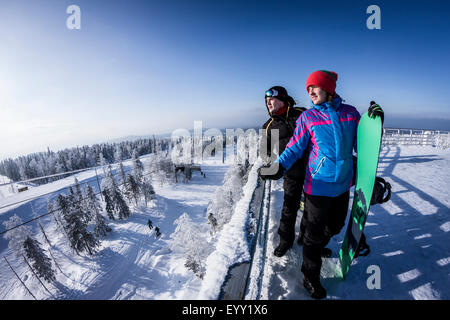 Gli appassionati di snowboard caucasica permanente sulla cima innevata Foto Stock