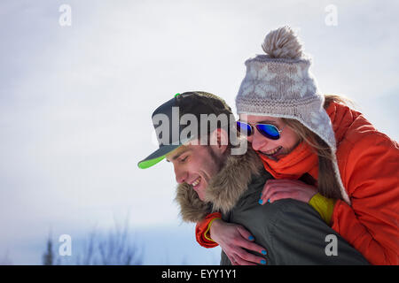 Uomo caucasico portando la fidanzata piggyback Foto Stock