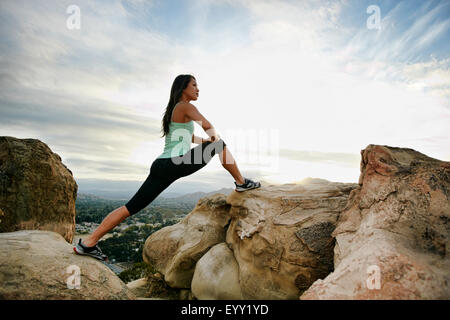 Donna vietnamita stiramento sulla collina rocciosa Foto Stock