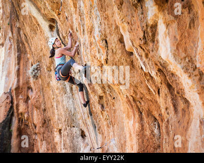 Razza mista ragazza arrampicata su parete di roccia Foto Stock