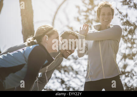 Close up di sorridere atleti stretching Foto Stock