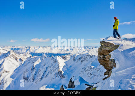 Escursionista ammirando vista panoramica dalla cima innevata Foto Stock