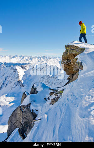 Escursionista ammirando vista panoramica dalla cima innevata Foto Stock