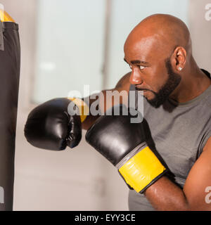 Boxer nero training con sacco da boxe Foto Stock