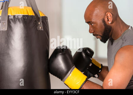 Boxer nero training con sacco da boxe Foto Stock