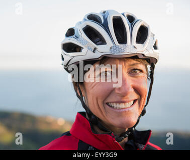 Close up di sorridere Caucasian donna che indossa il casco Foto Stock