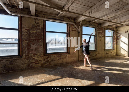 Caucasian ballerina di eseguire nella soleggiata loft Foto Stock