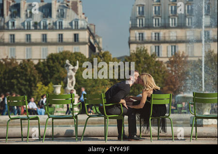 Coppia caucasica kissing vicino alla fontana nel parco urbano di Parigi e dell' Ile-de-France, Francia Foto Stock